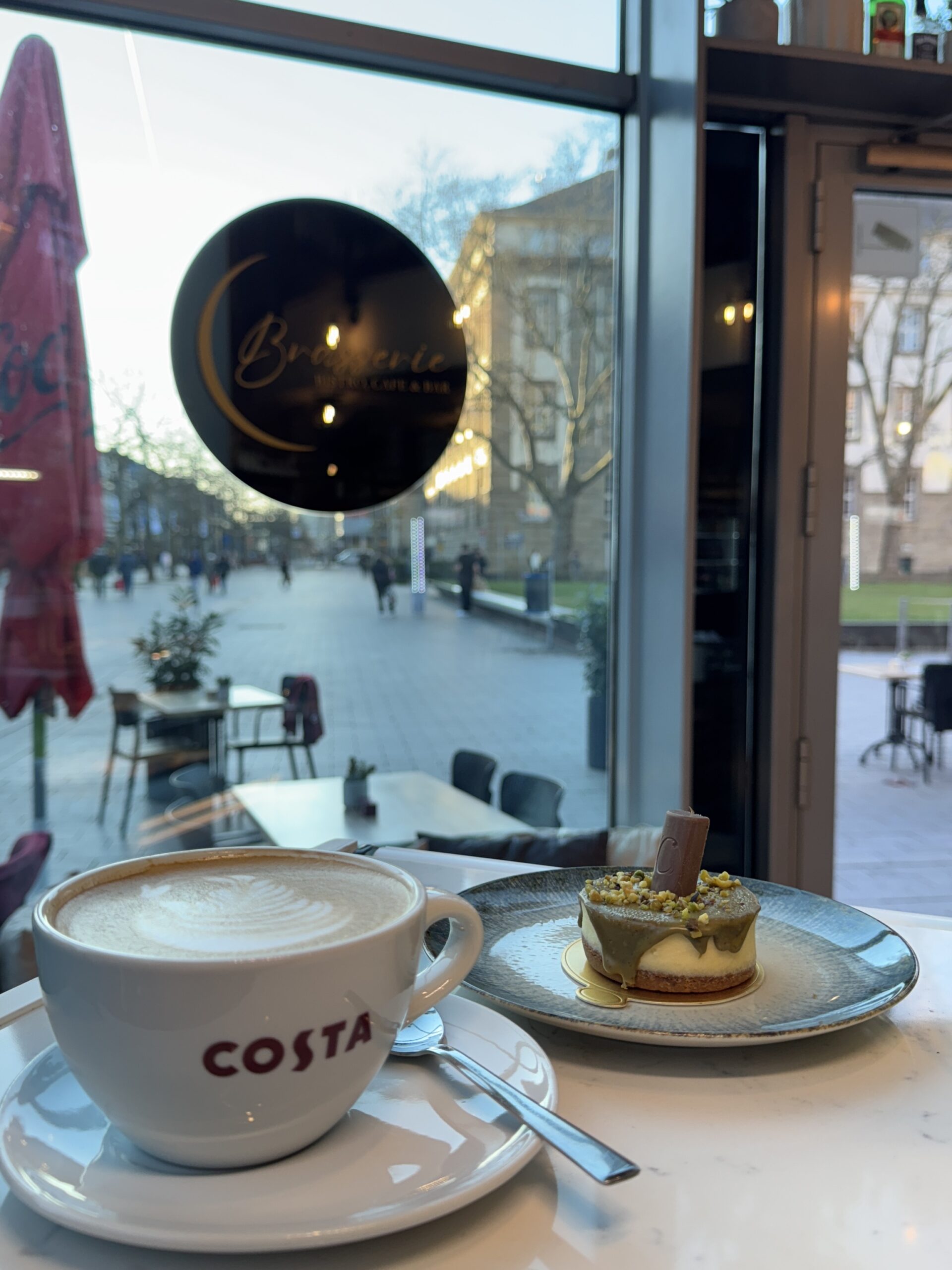 Cappucino und kleines Törtchen bei Brasserie